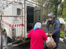 Рятувальник допомагає жінці сісти до евакомобіля