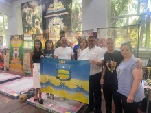 Учасники турніру тримають прапор громади. Жінки та чоловіки посміхаються.