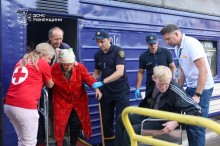 Представники служб та волонтери допомагають маломобільним людям вийти з потяга