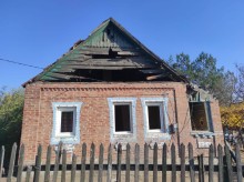 Будинок з пошкодженою покрівлею та вибитими вікнами