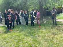 Група підлітків та дорослих разом з ветераном грають у спортивні ігри на галявині