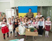 Діти-ВПО у вишиванках разом із військовим і вихователями на патріотичному заході, присвяченому підтримці захисників.
