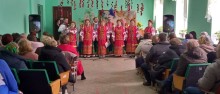 Виступ народного колективу на благодійнійному аукціоні «Разом ми сила!». Жінки співають у народних костюмах.