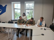 Учасники уроку «Донеччина – форпост незламної країни» за круглим столом. На передньому плані - військові.