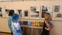 Троє відвідувачів розглядають експонати