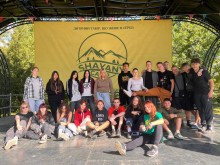 Діти з Новодонецької громади фотографуються на сцені на фоні банера табору