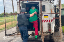 Рятувальники групи "Фенікс" саджають людину в евакуаційний автомобіль