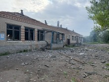 Одноповерхова будівля, яку зруйнував ворог та уламки цегли і шиферу навколо неї.