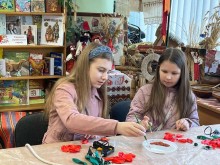 Дівчата декорують пелюстки маків, використовуючи пензлі та блискітки