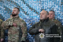 Поліцейські співають гімн України тримаючи руки біля серця.