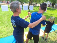 Два хлопчики під керівництвом інструктора стріляють з луків по мішенях.