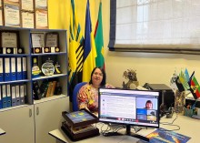 Представник військової адміністрації сидить за столом та слухає доповідача на семінарі