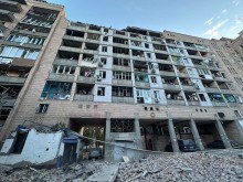 Зруйнований багатоповерховий будинок після ворожого обстрілу