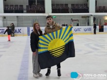 Молоді люди стоять на льоду у  льодовій арені та тримають прапор Донеччини.
