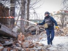 Фахівець піротехнічного підрозділу ДСНС огороджує стрічкою небезпечне місце.