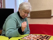 Жінка похилого віку грає в шашки