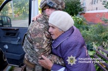 Поліцейський садить літню жінк в автівку