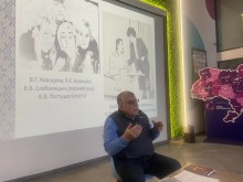 Педагог і дослідник Володимир Сутковий презентує історію бахмутського театру, сидячи перед екраном з архівними фото на заході у Києві