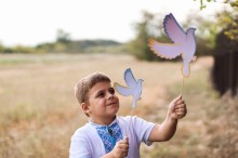 Конкурсна робота, на якій зображений хлопчик з паперовими голубами в руках