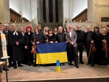 Учасники концерту зі скрипками на сцені тримають прапор України
