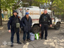 Евакуаційна група «Фенікс» та чоловік старшого віку біля евакуаційного автомобіля.