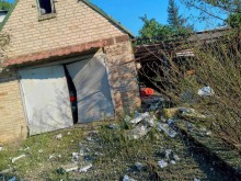 Пошкоджений гараж та будівельне сміття поруч із будівлею після обстрілу окупантів.
