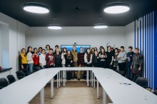 Військовий з групою підлітків, учасників телемосту у м. Київ, які тримають власноруч виготовлені обереги та браслети для захисників