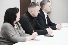 Представники громад, сидять за столом.