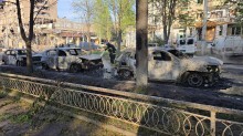 Рятувальник гасить вогонь на повністю згорілих автомобілях на вулиці в Краматорську