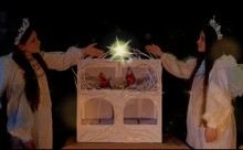 Дівчата в костюмах янголів тримають зірку над діорамою народження Христа