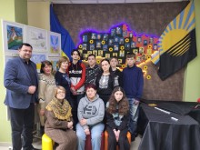 Спільне фото мешканців Сартанської громади. Позаду фотокартки загиблих захисників.