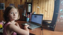 Дівчинка сидить за письмовим столом із відкритим ноутбуком, працює над завданням у межах Обласної екологічної експедиції.