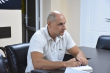 Учасник робочої групи, сидить за столом та уважно слухає доповідь.