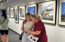 Мешканці Маріупольської громади відвідали екскурсію в мистецькому поїзді, розглядають брошури «Відвага нації», в яких зображена фотохроніка різних доль та місць України, незламність українського народу.