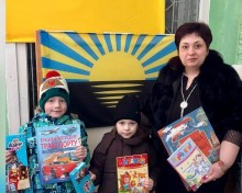 Діти Мирненської громади з книжками на фоні стягу Донеччини