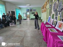 Юна художниця розповідає гостям виставки про свої картини