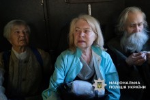 Дві жінки та чоловік літнього віку в евакомобілі