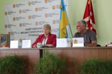 Білецька Галина голова Андрушівської громади та начальник Миколаївської міської військової адміністрації Володимир Проскунін. Сидять за столами та обговорюють розвиток та підтримку громад.