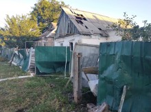 Зруйнований паркан та покрівля будинку після обстрілу.