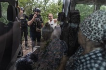 Волонтери та цивільний чоловік стоять біля дверей броньованого автомобіля. У салоні сидять люди похилого віку та маломобільні. Волонтер розповідає та пояснює процес евакуації.