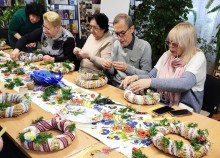 Учасники майстер-класу плетуть віночки під наставництвом музейників