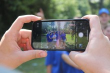 Діти фотографуються на смартфон разом з іншими підлітками, які приїхали на відпочинок.