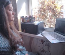 Представник військової адміністрації сидить за столом та слухає доповідача на семінарі