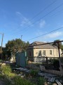 Одноповерховий будинок та забор, які пошкодило обстрілом з боку окупантів.