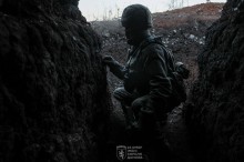 Військовий в окопі. У шоломі та броніжелеті.