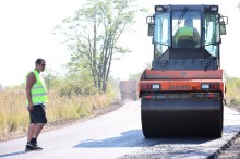 Працівник слідкує як працює асфальтноукладальник