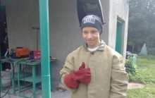 Хлопець у спеціальному одязі зварника демонструє у кадрі знак "окей"