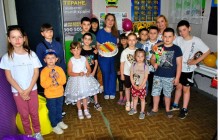 Групове фото дітей та організаторів заходу з тортом