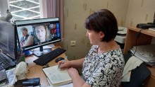 Представник військової адміністрації сидить за столом та слухає доповідача на семінарі.