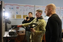 Вадим Філашкін та педагог у робочому костюмі, який показує на стенді електрозварювальний апарат.